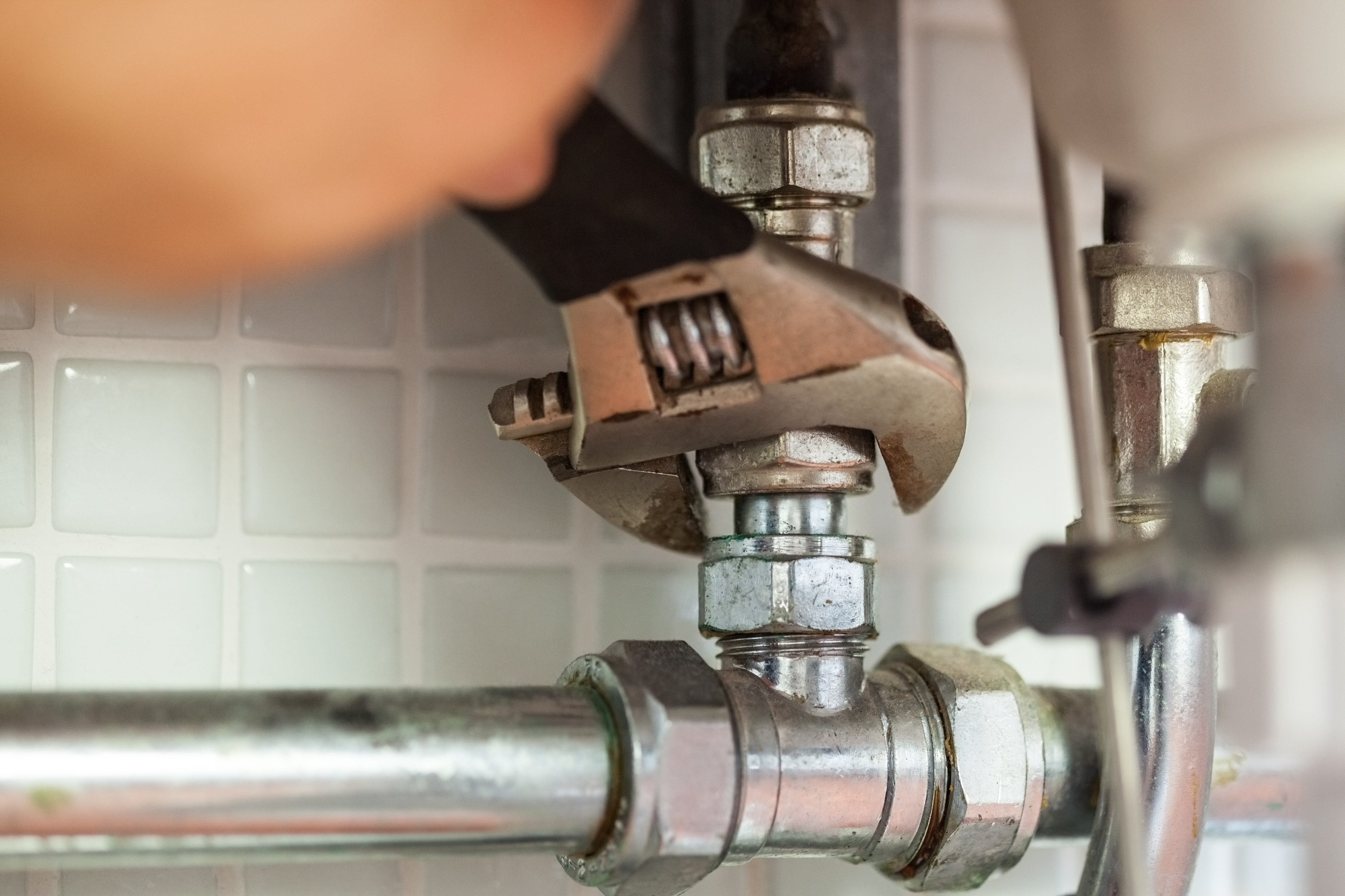 Close up of hand repairing pipes with wrench-1